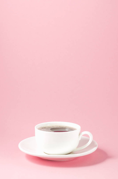 white cup with a saucer on a pink background/white cup with a saucer on a pink background with copy space - Foto, Imagem
