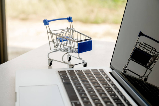 Košík umístěný vedle klávesnice notebooku Online nákupní nápady. - Fotografie, Obrázek