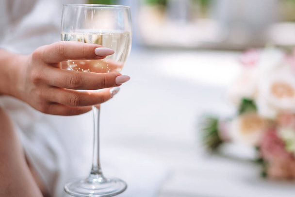 Uma taça de champanhe nas mãos da noiva
 - Foto, Imagem