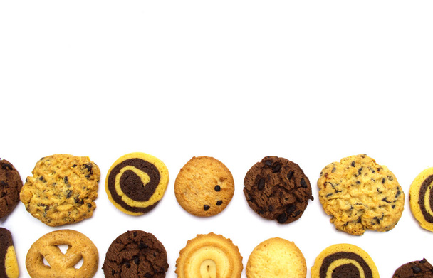 A group of assorted cookies. Chocolate chip, oatmeal, raisin, Danish cookies and biscuits in the shape of a spiral pattern isolated on white background and copy space. - Valokuva, kuva