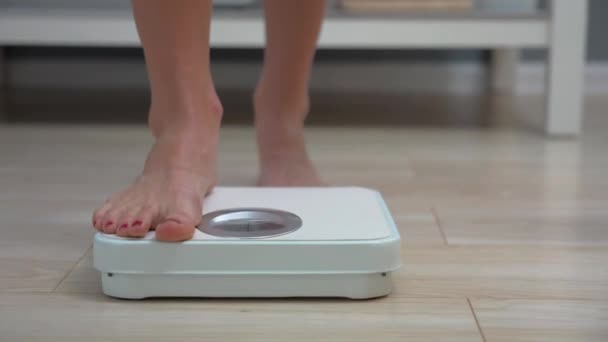 Mujer adulta comprobando peso en básculas de baño por la mañana
 - Metraje, vídeo