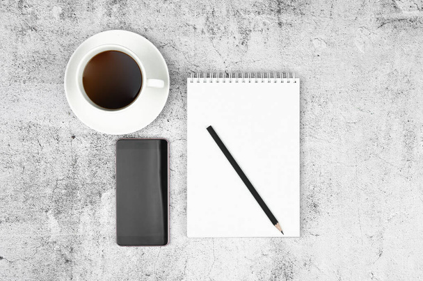 Telefoon en notitieblok lay-out met potlood en koffie op een vlakke lay. Uitzicht van bovenaf - Foto, afbeelding