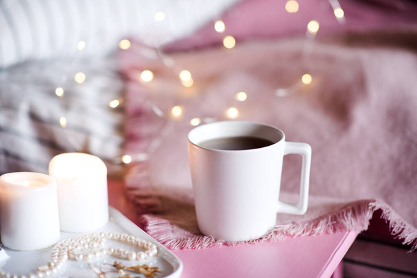 Tasse Tee mit Kerzen vor glühendem Hintergrund in Nahaufnahme. Guten Morgen.  - Foto, Bild