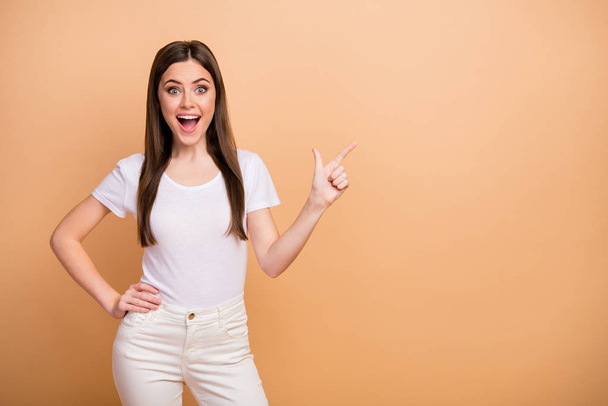 Portrait of astonished excited girl point index finger copyspace present incredible adverts impressed scream wow omg wear style stylish trendy outfit isolated over beige color background - Photo, Image