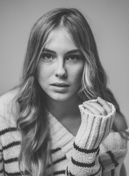 Portrait of teenager woman with perfect skin and long blond hair looking natural and beautiful. Black and white fashion art studio image of a female model in Fashion, beauty and advertising concept. - Foto, afbeelding