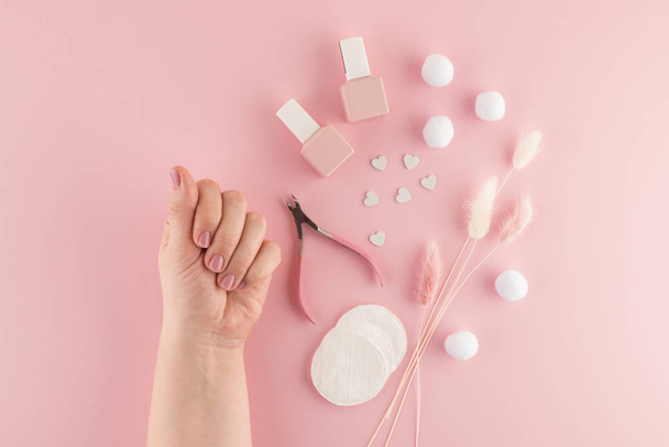 Beautiful female hands after spa procedures for skin care and beautiful manicure. Care for beauty and health in the salon or at home. Tool kit and material for manicure. Flat lay. Top view. - 写真・画像
