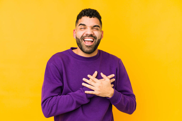 Young mixed race arabic man isolated laughing keeping hands on heart, concept of happiness. - Fotoğraf, Görsel