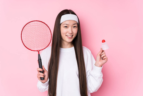 młoda Chinka gra badminton odizolowany szczęśliwy, uśmiechnięty i wesoły. - Zdjęcie, obraz