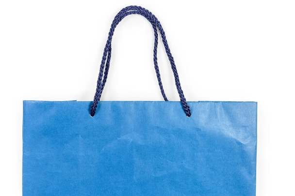 Bolsa de compras de papel azul, parte superior con asas de cuerda textil, primer plano sobre un fondo blanco, textura, fondo
 - Foto, Imagen