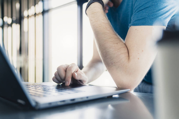 крупним планом рука людини використовує ноутбук зі світлом з фону вікна
 - Фото, зображення