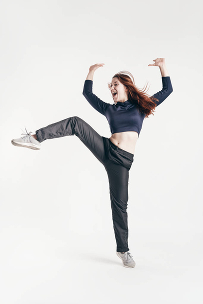 brunette girl shows dance elements on a white background - Foto, imagen