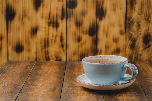 Blue cup of tea on wooden background, selective focus and copyspace for text - Zdjęcie, obraz