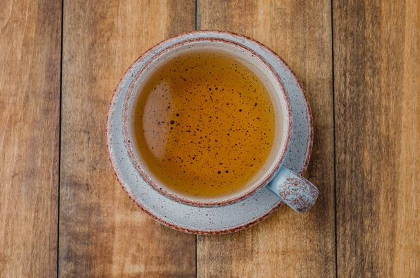 Blue cup of tea on wooden background, top view - Photo, image