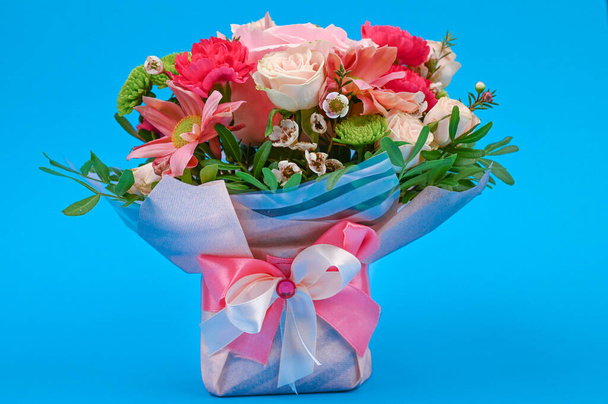 Bouquet of flowers on a blue background. Congratulations to the women. Flowers are loved. Place for writing. Flat lay - Photo, Image