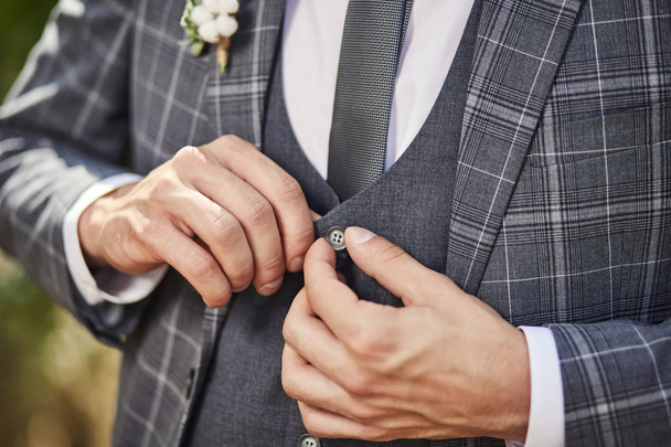 Empresário usa uma jaqueta, mãos masculinas close-up, noivo se preparando pela manhã antes da cerimônia de casamento - Foto, Imagem