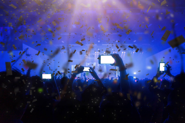 Люди наслаждаются живой музыкой концерт рука держать смартфон для захвата прекрасный момент со светом и лазерный эффект на сцене
 - Фото, изображение
