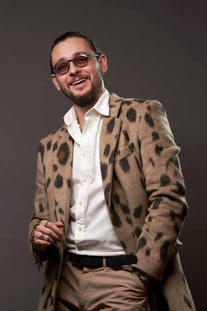 Happy male in sunglasses in jacket on brown background - Zdjęcie, obraz