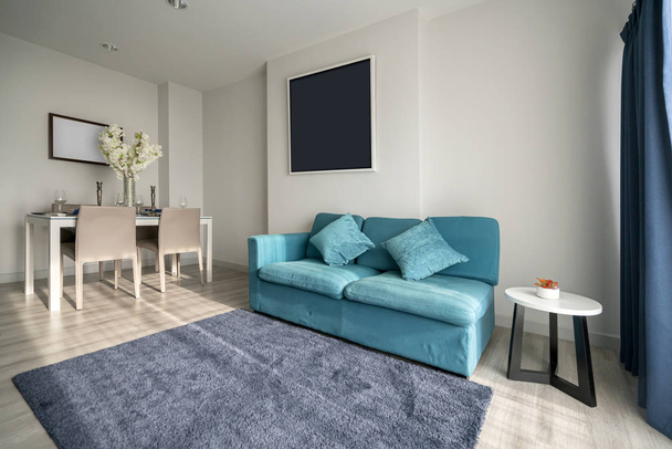 мінімальний дизайн інтер'єру квартири з синім диваном і дерев'яним обіднім столом домашній фон
 - Фото, зображення