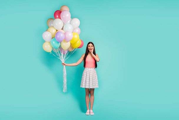 Full size photo of astonished girl celebrate festive event impressed by air baloons touch hands face scream wow omg wear pastel singlet footwear isolated over teal color background - Photo, Image