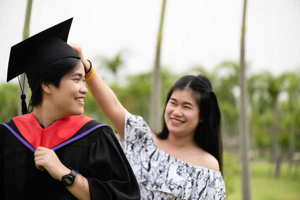 Diplomaosztó. Fiatal női diplomás a barátjával gratulál a diáknak az egyetemen. - Fotó, kép