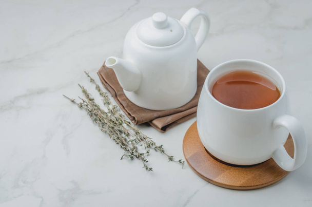 Thyme herbal tea, White cup with tea and kettle. - Φωτογραφία, εικόνα