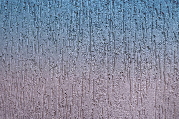 Kőből készült dekoratív vakolat vagy betonfal textúrája kék rózsaszín gradienssel. - Fotó, kép