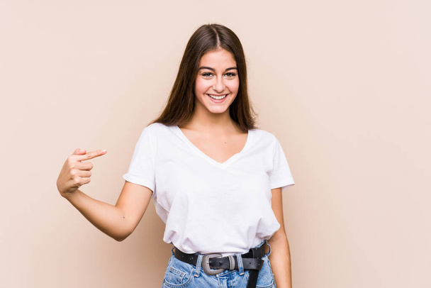 Giovane donna caucasica posa persona isolata che punta a mano ad uno spazio copia camicia, orgoglioso e fiducioso - Foto, immagini
