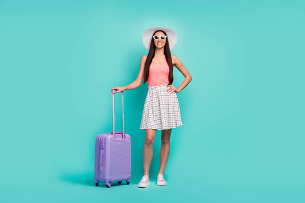 Luxury resort wait me. Full body photo positive cheerful girl ready travel summer weekends hold first-class suitcase wear sunglass sunhat singlet footwear isolated turquoise color background - 写真・画像