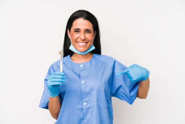 Mujer dentista aislada sobre fondo blanco persona señalando a mano a un espacio de copia de la camisa, orgulloso y confiado
 - Foto, Imagen