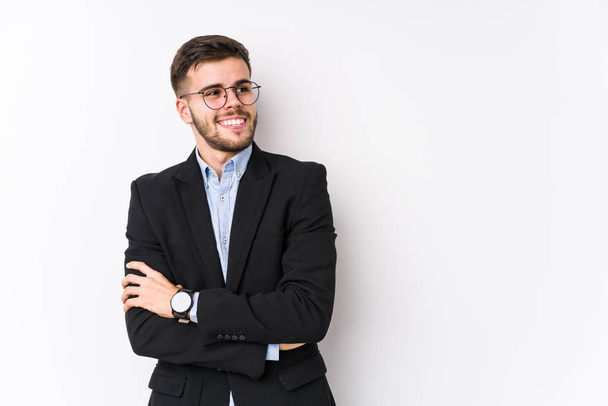 Молодий кавказький бізнесмен позує на білому тлі ізольований Молодий кавказький бізнесмен посміхається впевнено схрещеними руками
. - Фото, зображення