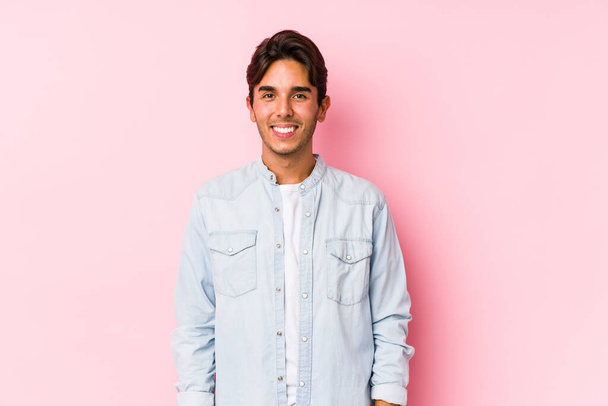 Young caucasian man posing in a pink background isolated happy, smiling and cheerful. - Photo, image