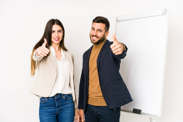 Young caucasian business couple isolated with thumbs ups, cheers about something, support and respect concept. - Photo, Image