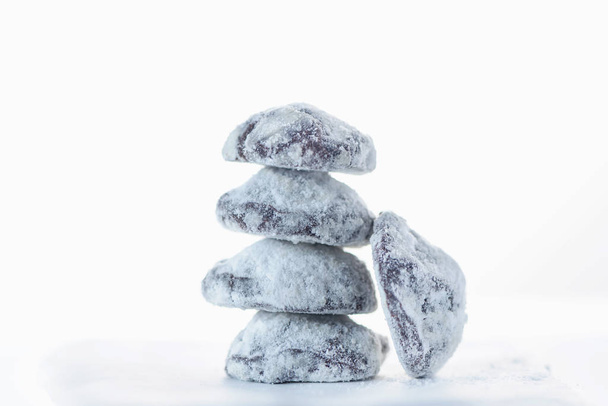 Five chocolate crinkle cookies on a white baking paper, close up, isolated, still life photography - Foto, Bild