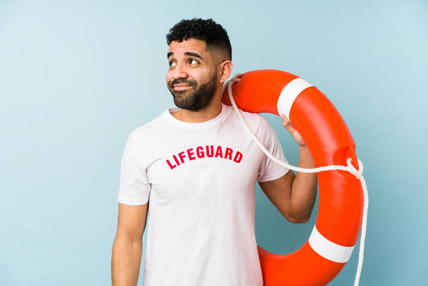 Young latin lifeguard man isolated dreaming of achieving goals and purposes - Valokuva, kuva