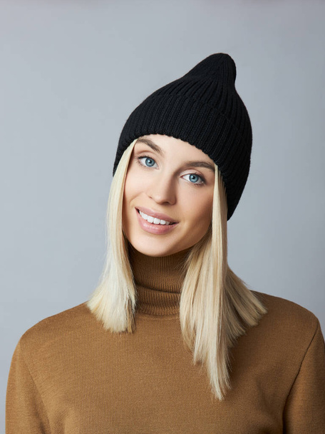 Woman in spring clothes, Snood scarf, hat and gloves. The girl is blonde with blue eyes. Warm clothing for cold spring weather - Fotoğraf, Görsel