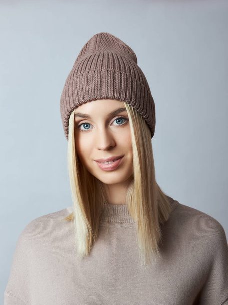 Woman in spring clothes, Snood scarf, hat and gloves. The girl is blonde with blue eyes. Warm clothing for cold spring weather - Foto, Bild