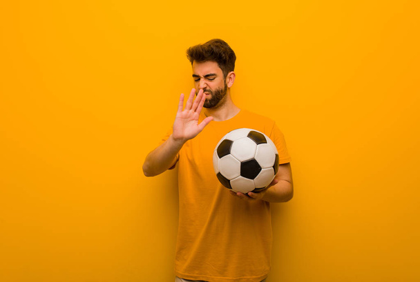Joven jugador de fútbol hombre poniendo la mano en frente - Foto, imagen