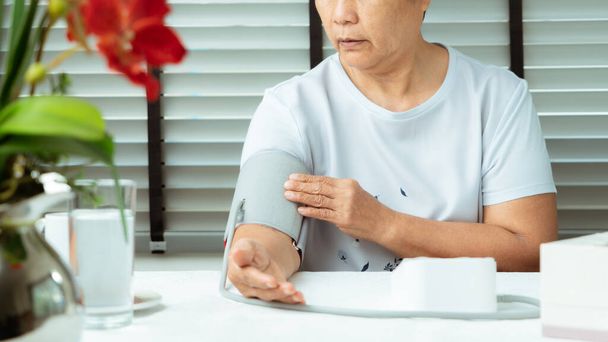 senior woman is detecting blood pressure at home - Foto, Imagem