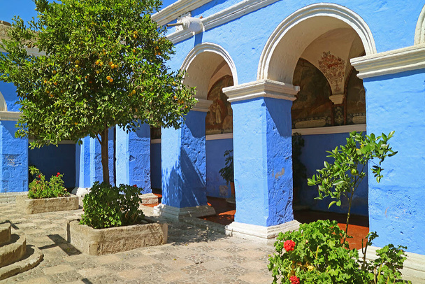 Wunderschöner Kreuzgang mit leuchtend blauen Säulen und Wandfresken im Kloster Santa Catalina, Arequipa, Peru - Foto, Bild