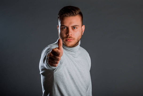 Attraktiver junger stylischer Mann posiert im Strick-Polo-Nacken-Pullover - Foto, Bild