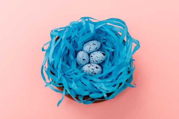 High angle view of quail eggs in blue nest on pink background, easter concept - Φωτογραφία, εικόνα