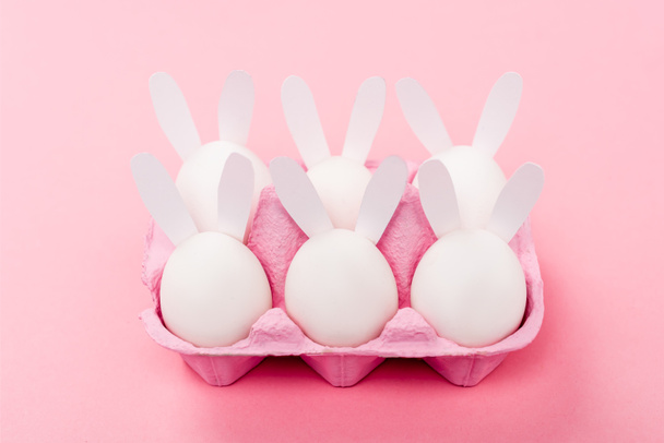 Decorative easter bunnies in egg tray on pink - Foto, Bild