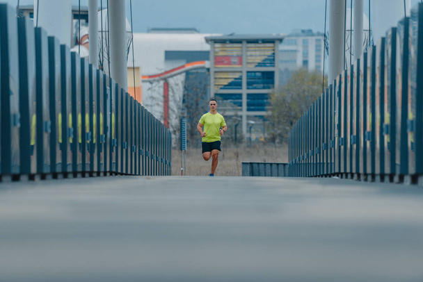 40 év feletti, hídon átfutó aktív ruhás atlétikai férfi - Fotó, kép
