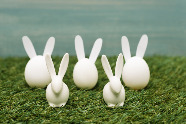 Lapins de Pâques blancs décoratifs sur l'herbe
 - Photo, image
