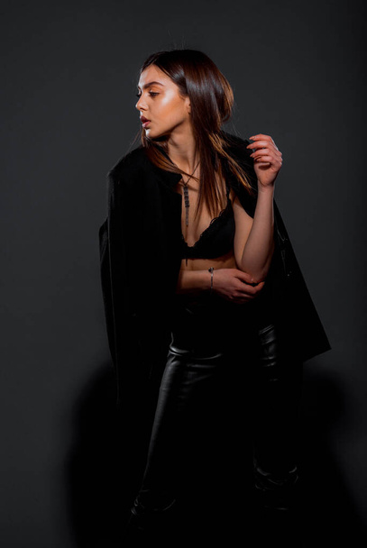Houkutteleva nuori nainen malli poseeraa tyylikäs musta takki - Valokuva, kuva