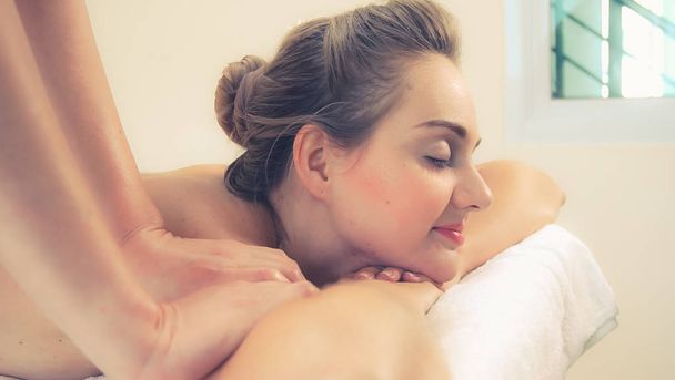 Ontspannen vrouw krijgt terug massage in luxe spa met professionele massage therapeut. Wellness, genezing en ontspanning concept. - Foto, afbeelding