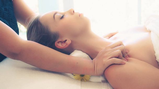 Relaxed woman getting shoulder massage in luxury spa by professional massage therapist. Wellness, healing and relaxation concept. - Photo, Image