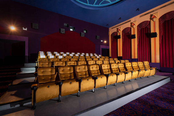 シネマトグラフ・プロジェクターで映画館のプレミアに座るための観客のためのシート行と大規模な映画館の劇場のインテリア。映画館は映画鑑賞の贅沢感のために古典的に装飾されています. - 写真・画像