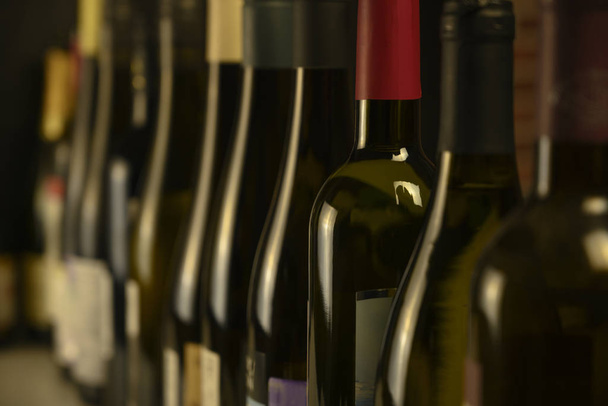 Viele Flaschen Wein stehen hintereinander im Keller - Foto, Bild