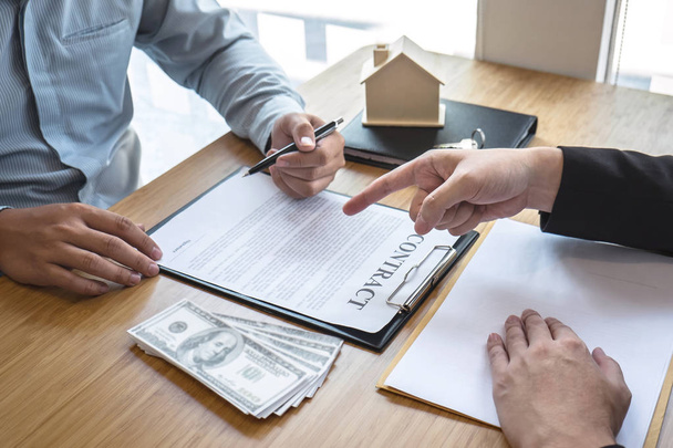 Real estate agent are presenting home loan and giving house, keys to customer after signing contract to buy house with approved property application form. - Foto, imagen